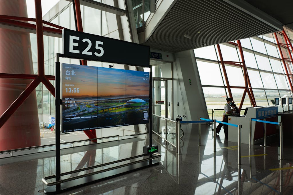 Traveler with luggage at Beijing Airport checking smartphone connectivity immediately after landing.
