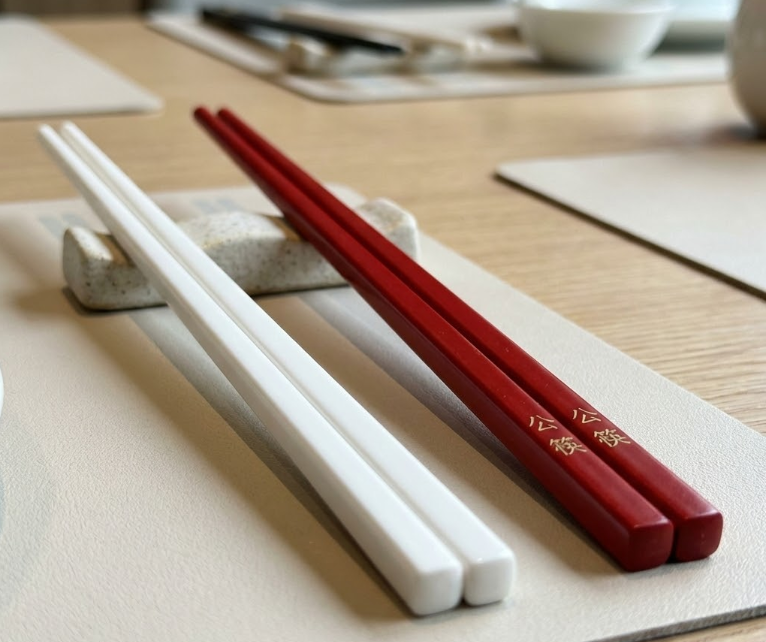 Using public serving chopsticks in 2026 China corporate dining etiquette.